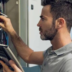 Man working in electrical control cabinet 