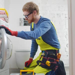 Repairman fixing broken washer