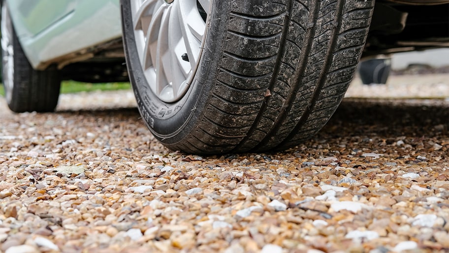 Close up of a tire on gravel driveway