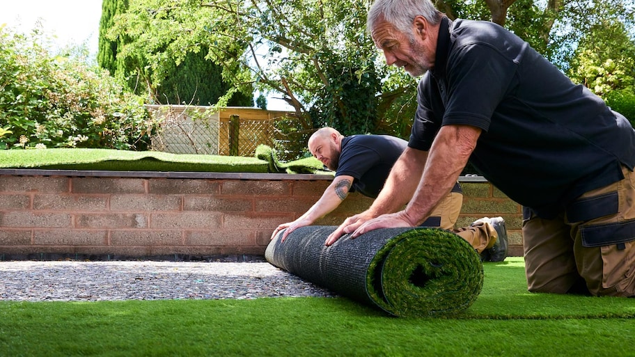 Two workers installing artificial grass