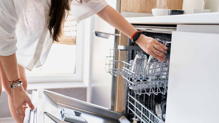 Woman opening dishwasher