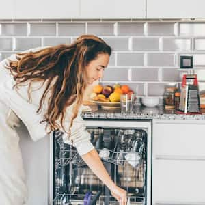 Woman putting dishes in dishwasher