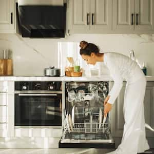 Woman putting dishes in dishwasher