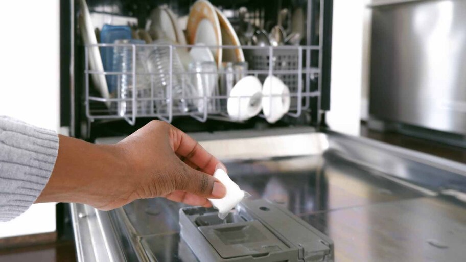 Woman putting dishwasher detergent 