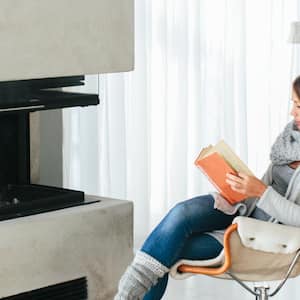  A woman reading book in front of fireplace