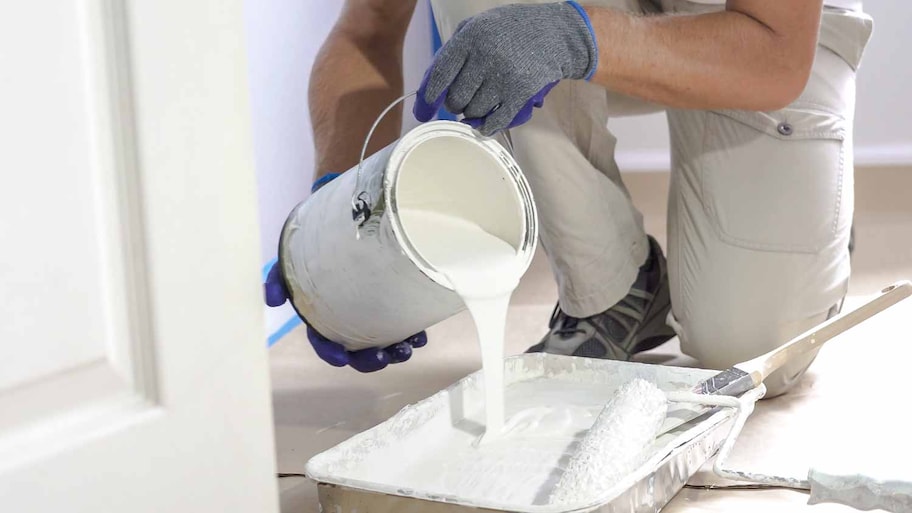 Worker pouring white color paint