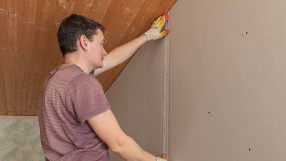 Workers installing tape on drywall