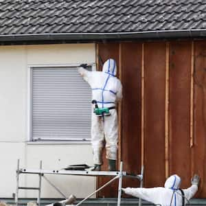 Workers in protective suits removing asbestos