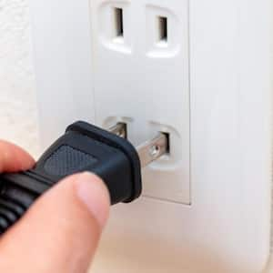 inserting plug into wall outlet