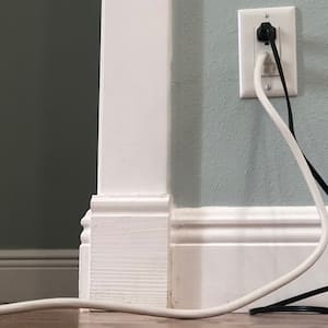 close up of wall with electrical outlet and cords