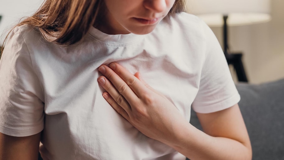 woman holding chest having trouble breathing