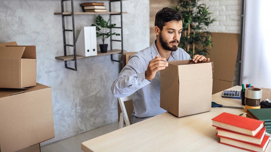 Man assembling cardboard box to pack his books