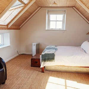 Bright attic bedroom with sofa and bed