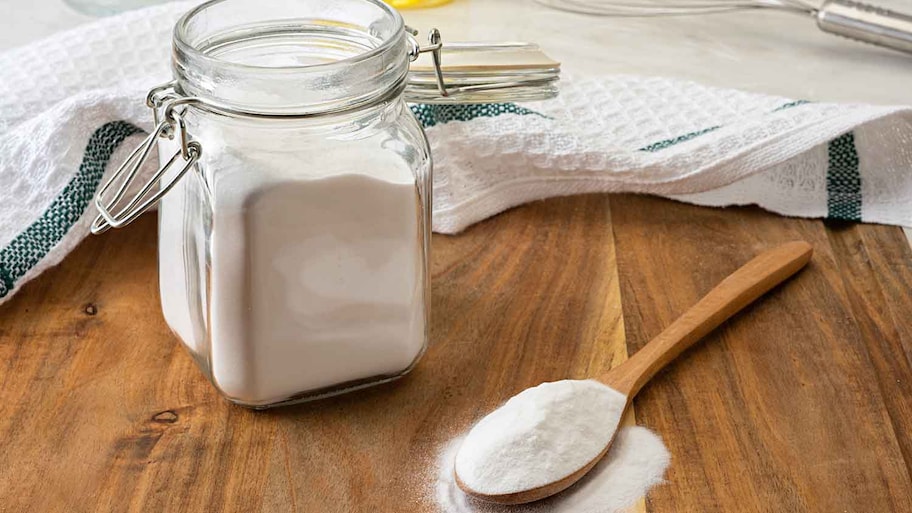 Baking soda in a jar and a wooden spoon