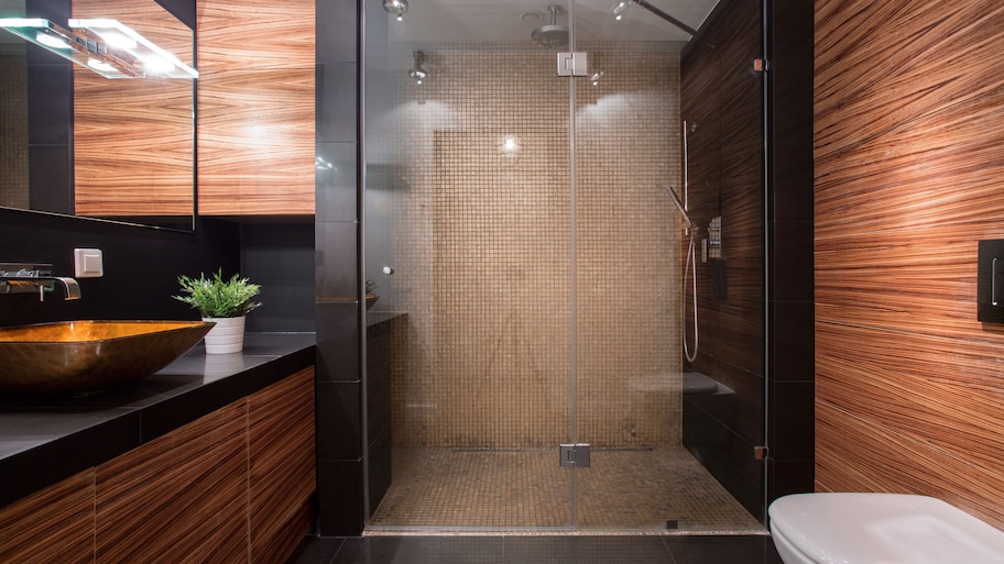 Modern bathroom with wood paneling, large shower, and black tile backsplash 