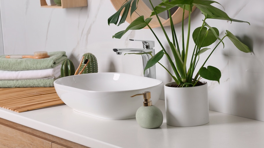 Modern bathroom with a marble backsplash, wooden vanity, and white vessel sink