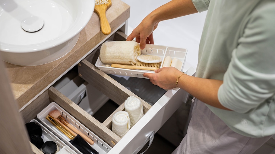 woman organizing bathroom drawer 