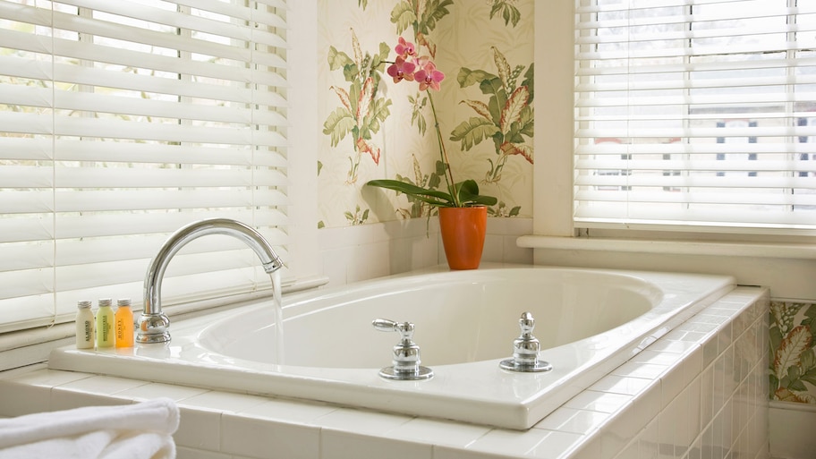 Bathtub with running water in a white bathroom