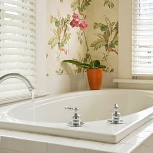 Bathtub with running water in a white bathroom