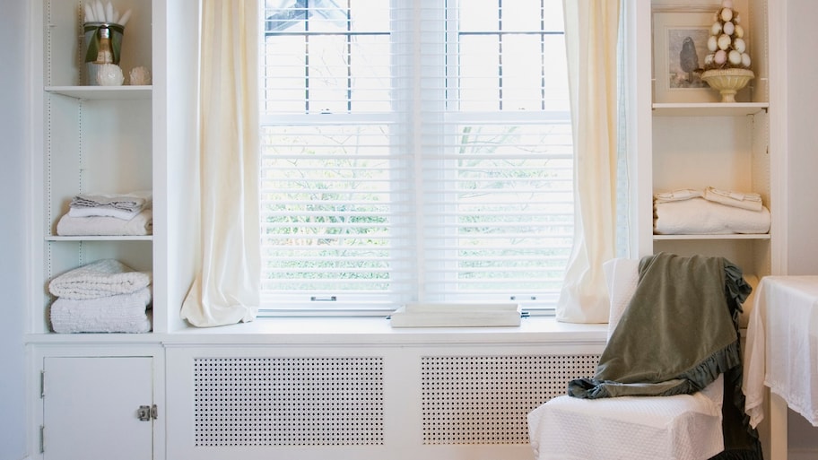 The interior of a bedroom with a chair by the window