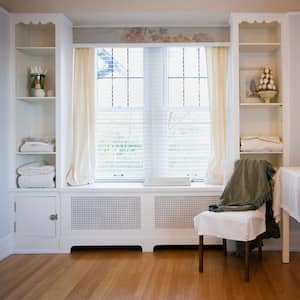 The interior of a bedroom with a chair by the window