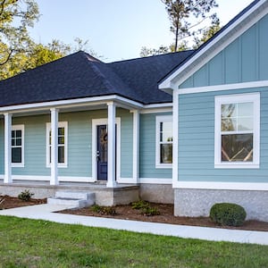 blue ranch style home with asphalt shingles  