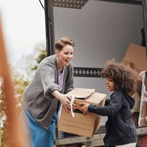 Boy helping mother in unloading cardboard box