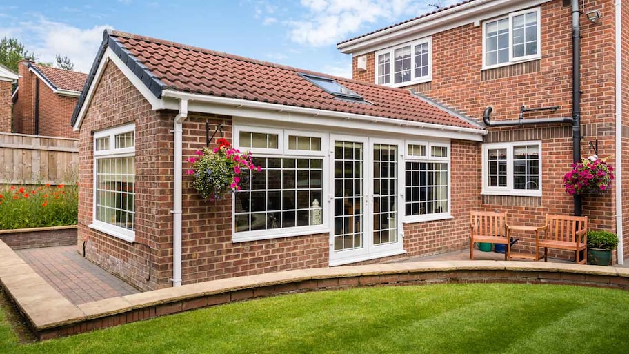 A brick house with a sunroom facing the backyard