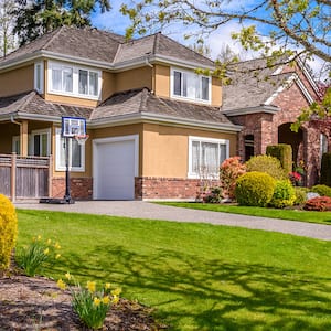 brown brick house with tree in yard