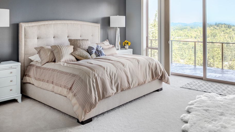  A spacious carpeted bedroom with a nature view from the window