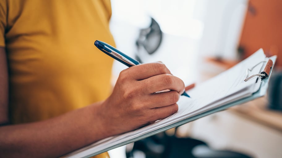 woman taking notes on clipboard