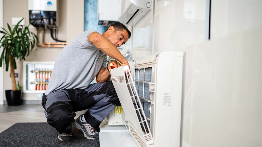 man cleaning air conditioner filter