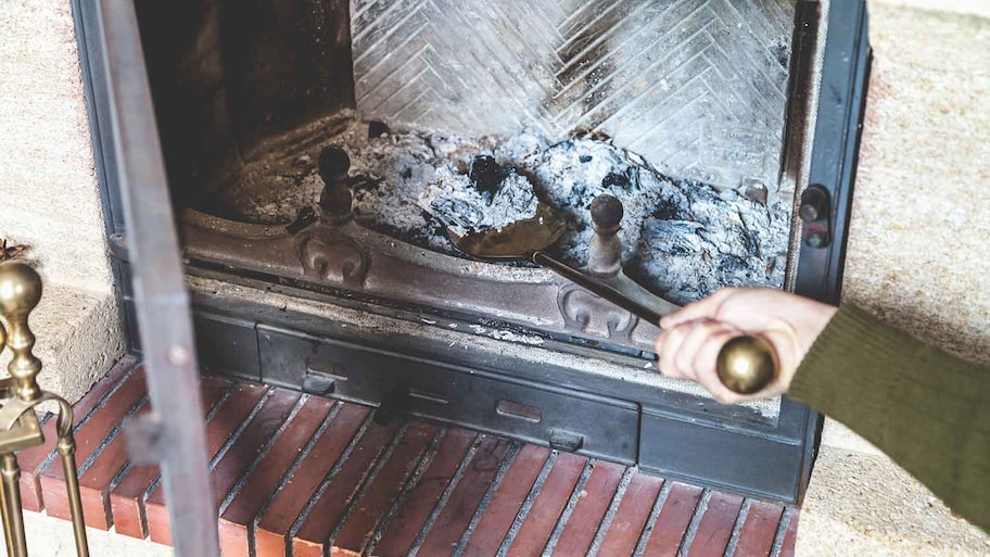 Man shoveling ashes out of the fireplace