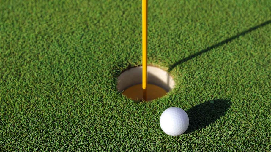 Close-up of a golf ball next to the hole