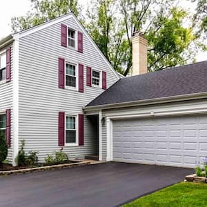 white colonial house with asphalt driveway