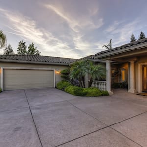 a concrete driveway outside a garage and home during sunset