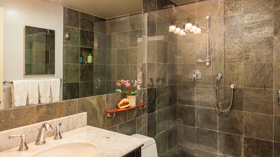 A contemporary bathroom with granite tiles and a shower