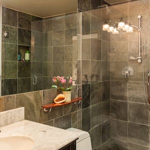 A contemporary bathroom with granite tiles and a shower