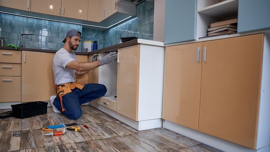 Contractor works on installing cabinets in a new kitchen