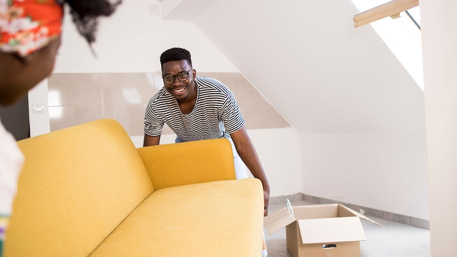 Couple carrying yellow sofa