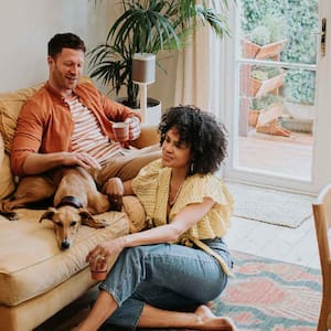 A couple relaxing in the living room with their dog