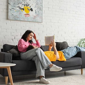 Couple sitting on a couch reading a book