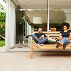 Couple sitting on a couch on the patio using their phones