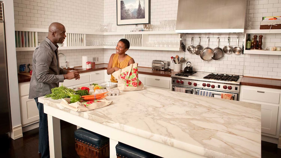 Couple in the kitchen unbagging groceries