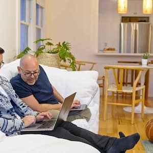 Couple sitting on a sofa using their laptops