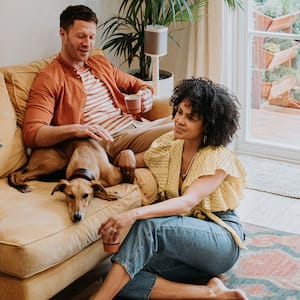 Couple relaxing in living room with dog 