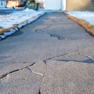 crack in residential sidewalk due to weather