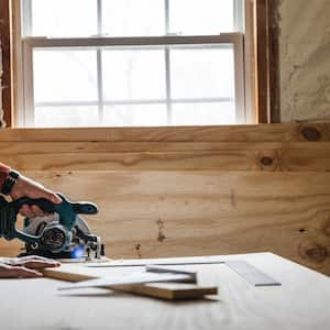 Carpenter cutting a piece of plywood with a circular saw