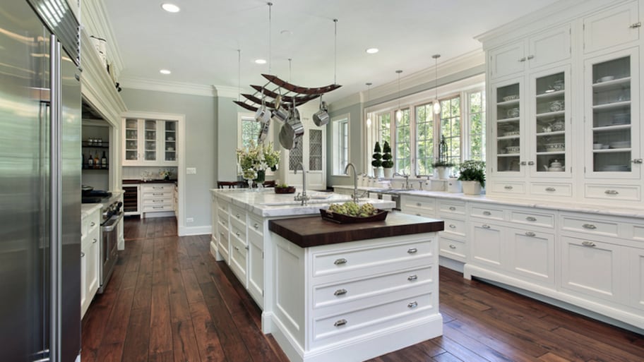 Large two-tiered kitchen island in white kitchen