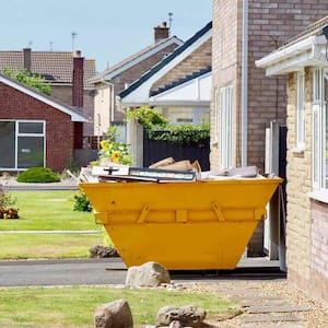 dumpster truck in front of house